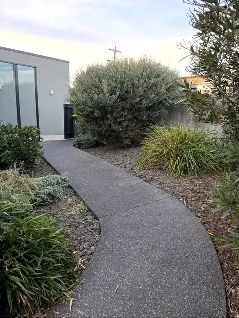 Concrete path with mulched garden beds (before)