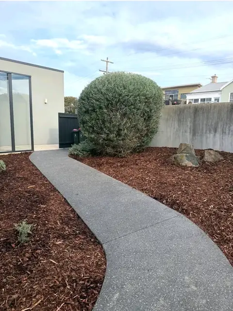 Concrete path with mulched garden beds