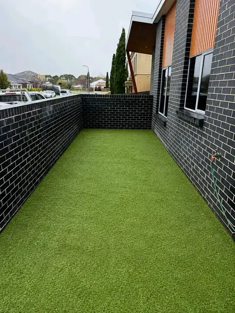 Side passage with artificial turf and gravel (before)